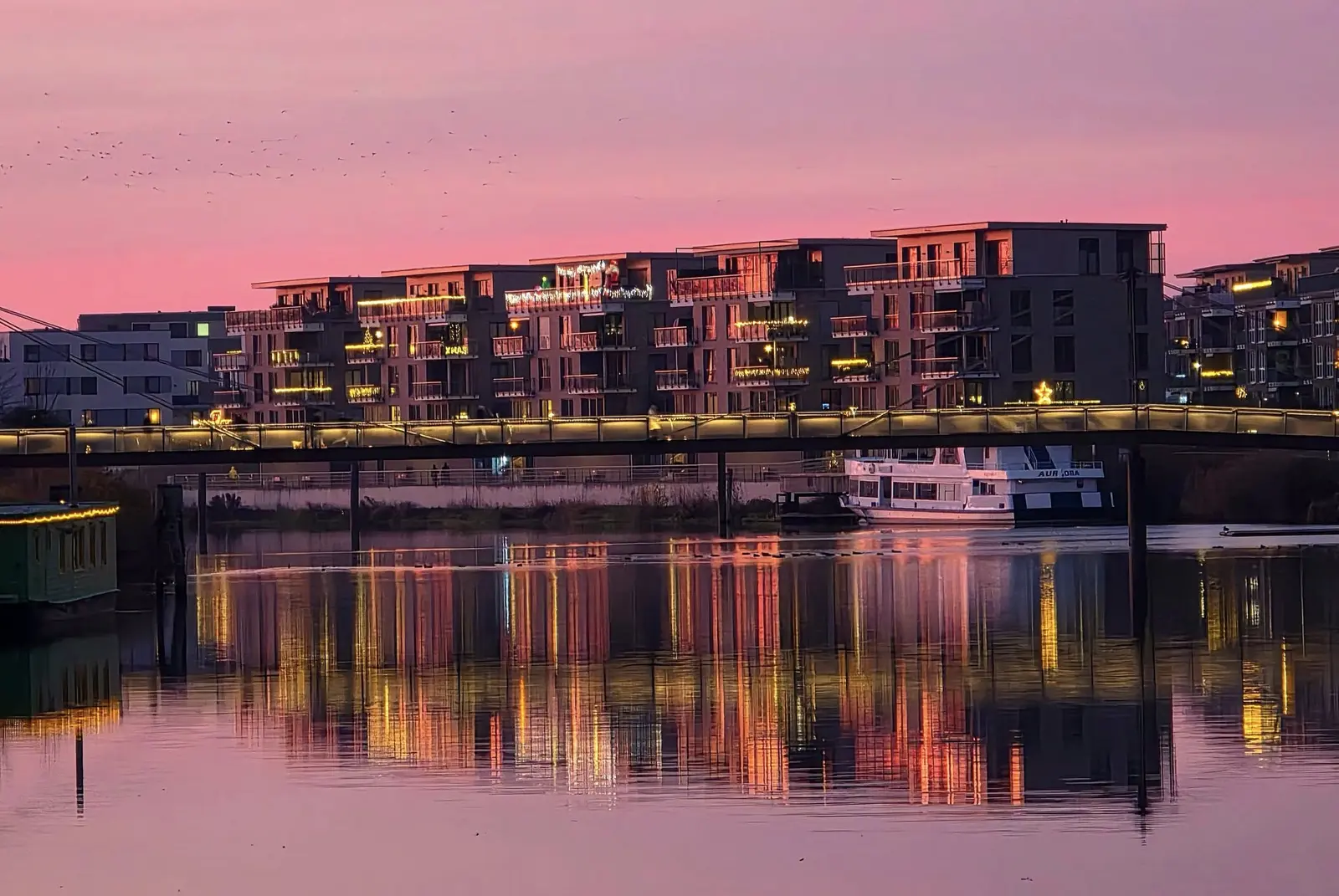 Hafen und beleuchtete Uferpromenade in der Abenddämmerung